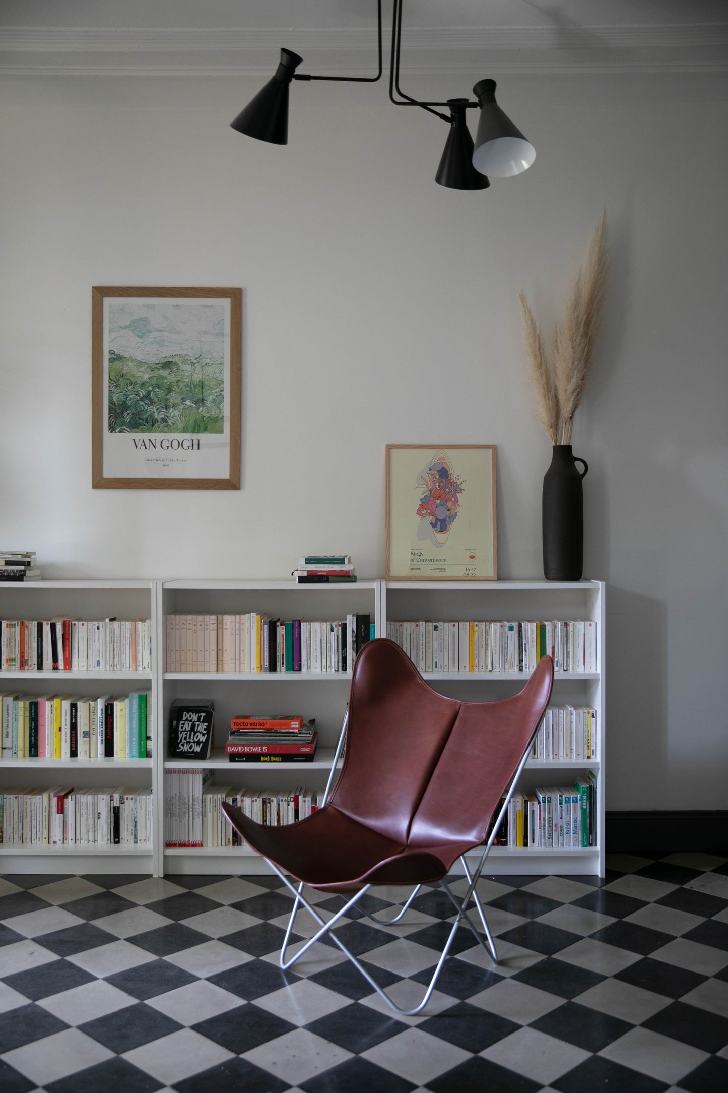 Fauteuil Papillon Cuir bordeau - Structure inox - Vue de 3/4 dans une bibliothèque