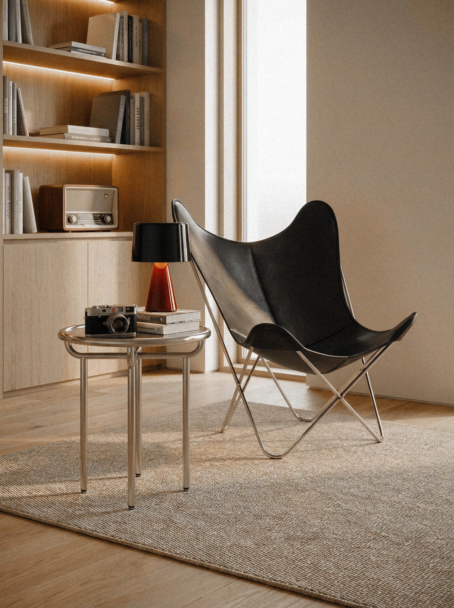Fauteuil Papillon Cuir noir - Structure inox - Vue 3/4 dans un salon