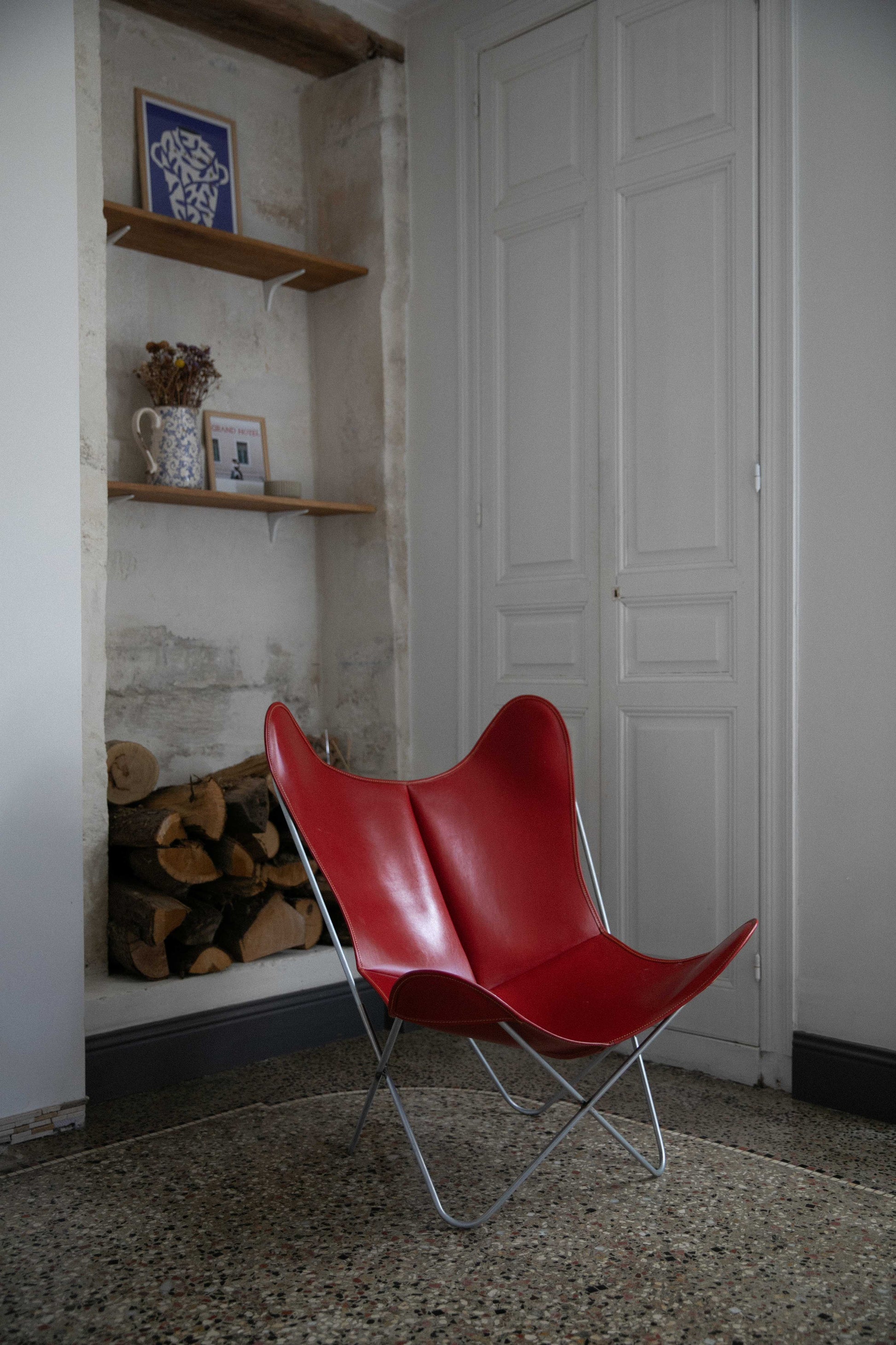 Fauteuil Papillon Cuir rouge - Structure inox - Vue de 3/4 dans un salon