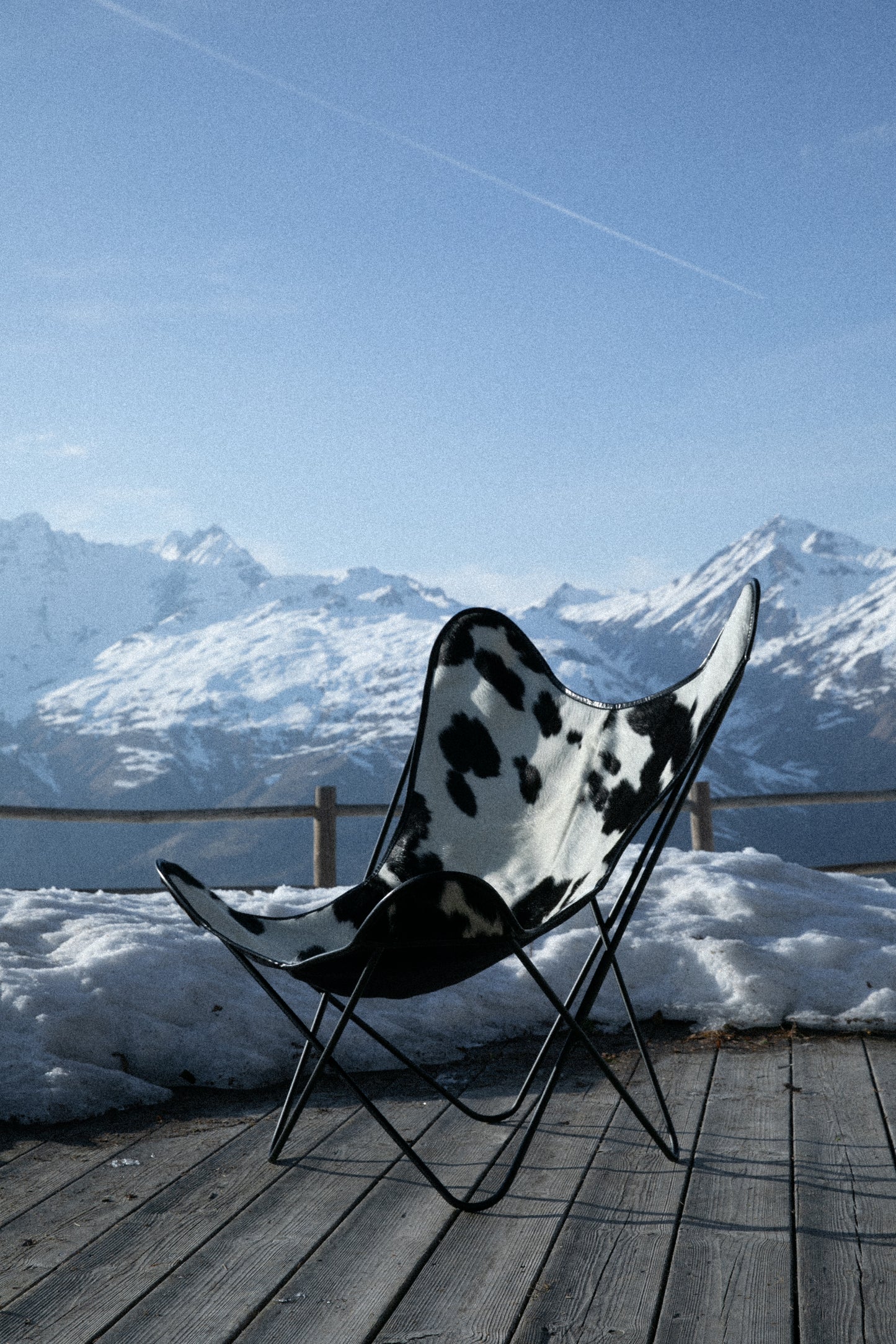 Fauteuil Papillon Cuir Vache Noire -  Structure Noire - Vue de 3/4 sur une terrasse à la montagne
